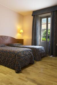 瓦拉洛意大利达尔贝戈酒店的酒店客房设有两张床和窗户。