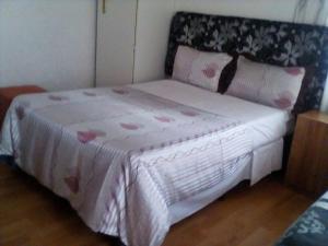 约翰内斯堡麦考利旅馆的一间卧室配有一张粉色和白色床单。