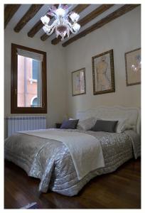 威尼斯多莫斯迪亚公寓的一间卧室配有一张带吊灯的大床