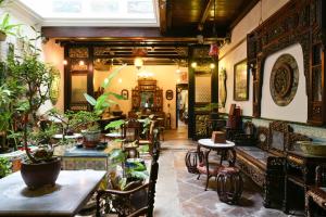马六甲荷仁博物馆5号酒店的一间设有桌椅的餐厅,种植了植物