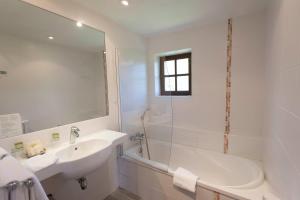 勒波埃拉瓦勒医院酒店的白色的浴室设有浴缸、水槽和淋浴。