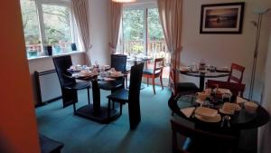 塔伯特Bluebell Cottage的用餐室设有桌椅和窗户。