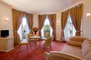 卢尔德现代大酒店的客厅配有沙发和桌椅
