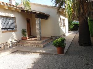 利乌玛Villa Pepito的房屋前方有楼梯和棕榈树