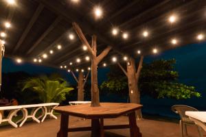 Puerto ArmuellesBig Daddy's Beach Club & Hotel的天井配有木桌和灯。