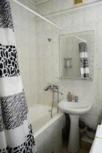 苏梅Apartment on Petropavlivs'ka 90的浴室配有水槽、浴缸和淋浴帘