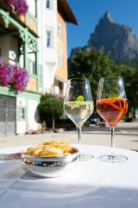 修希NaturResidence Dolomitenhof的两杯酒和一盘桌上的食物