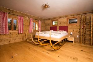 巴德哥依斯恩洛基斯2324公寓的卧室配有一张床铺,位于带木墙的房间内