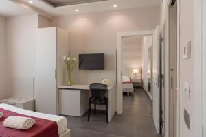 阿里亚诺伊尔皮诺碧非格兰德酒店的一间卧室配有一张床和一张书桌及电视