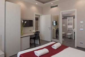 阿里亚诺伊尔皮诺碧非格兰德酒店的一间带一张床和一张书桌的卧室以及一间浴室。