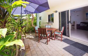 米申海滩使命珊瑚礁度假酒店的庭院配有桌椅和遮阳伞。