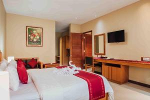 库塔Kuta Puri Bungalows, Villas and Resort的配有一张床和一张书桌的酒店客房