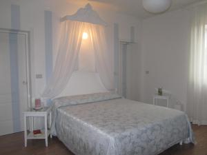 洛雷托·阿普鲁蒂诺B&B Le Stagioni的卧室配有白色的床和2张桌子
