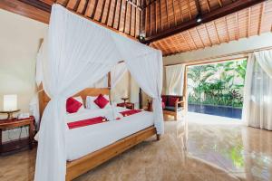 库塔Kuta Puri Bungalows, Villas and Resort的一间卧室配有一张带蚊帐的床