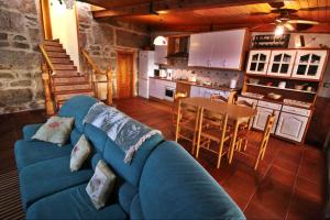 格罗韦Casa Balbina的一间带蓝色沙发的客厅和一间厨房