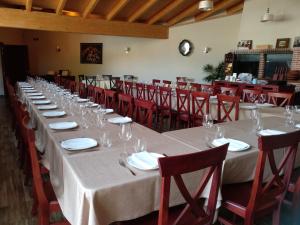 Pesquera de Duero拉波萨达德佩斯克拉宾馆的长桌,带酒杯和红椅子