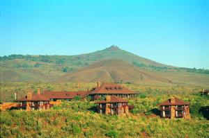 奈瓦沙东非大裂谷旅舍及高尔夫度假酒店的山丘上的房子,背景是山