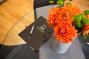 罗马Amazing Piazza Venezia Suites的一张带橘子花花瓶的桌子和一张卡片
