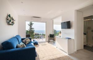 卡莱利亚德帕拉弗鲁赫尔Azteka Blue 2 Bed Apartment Calella de Palafrugell的客厅配有蓝色沙发,享有海景