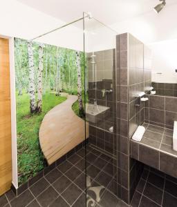 欣费尔德罗恩霍夫酒店的一间带淋浴的浴室,配有树木壁画