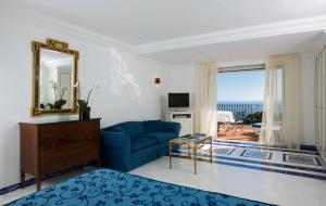 卡普里卡萨莫格诺酒店的客厅配有蓝色的沙发和镜子