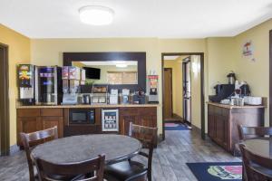 楠帕爱达荷州南帕速8酒店的一间带桌子的用餐室和一间带柜台的厨房