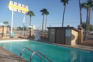 Gila BendPalms Inn的一个带酒店标志和棕榈树的游泳池