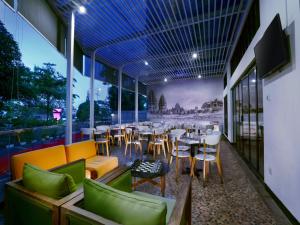 日惹日惹马里奥波罗酒店的餐厅设有桌椅和窗户。
