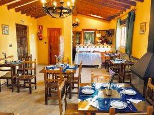 桑提亚纳德玛卡巴纳德萨蒙旅馆的餐厅设有木桌、椅子和一张带自助餐的桌子。