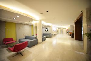 曼谷帕拉索@罗查达12酒店的大楼内一个带沙发和椅子的大堂
