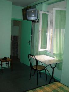 希农堡里奥多赫酒店及餐厅的客房设有桌子、电视和窗户。
