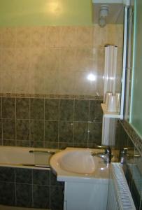 希农堡里奥多赫酒店及餐厅的浴室配有盥洗盆和浴缸。