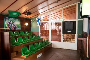 玛丽港阿德隆酒店的一间设有绿色椅子和电视的等候室