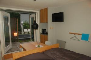 WaalreB&B EINDHOVENnearby的一间卧室配有一张床铺和一张桌子,还有一间用餐室