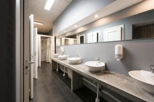 隆德文思特鲁普旅社的浴室设有4个水槽和一排镜子