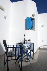 佩里萨森姆普罗客房酒店的一张桌子、两把椅子和一瓶葡萄酒