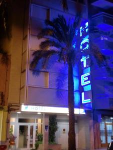 贝尼卡洛埃尔品奇德奥洛酒店的前面有棕榈树的酒店