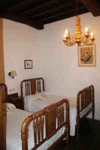 科斯加亚Casona de Treviño的一间卧室配有两张床和吊灯。