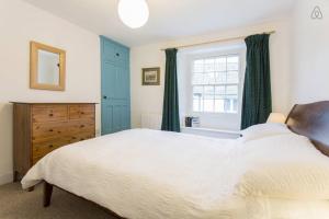 圣莫斯Fisherman's Cottage的一间卧室设有一张大床和一个窗户。