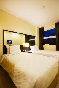 独鲁万塔克洛班酒店的酒店客房设有两张床和窗户。