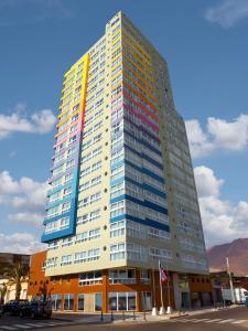 伊基克Gran Cavancha Hotel & Apartment的一座高大的办公室大楼,有彩虹