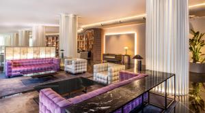瓦伦西亚SH瓦伦西亚宫酒店的客厅配有紫色沙发和桌子