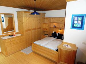 科瓦拉因巴迪亚Ciasa Confolia的卧室配有一张床铺,位于带木墙的房间内