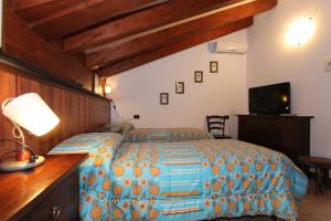Molini di TrioraAlbergo Santo Spirito的一间卧室配有一张床、一张书桌和一台电视
