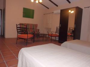 马尔帕尔蒂达德卡塞雷斯卡萨乡间玛丽亚旅馆的一间设有两张床、椅子和一张桌子的房间