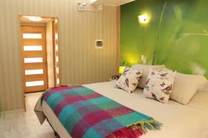 维库尼亚Organica Lodge Spa的一间卧室配有一张带绿色墙壁的床