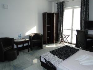 比得哥什阿加特SPA酒店的卧室配有一张床和一张桌子及椅子
