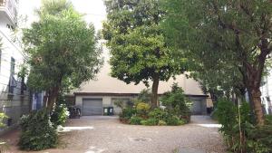 米兰布罗尼佐之家旅馆的两扇车库门和树木的房子
