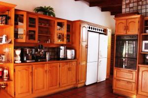 约翰内斯堡约克之家酒店的厨房配有木制橱柜和白色冰箱。