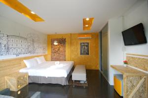 卡马拉海滩SHA The Regent Resort Phuket Kamala Beach的一间卧室配有一张床和一台平面电视